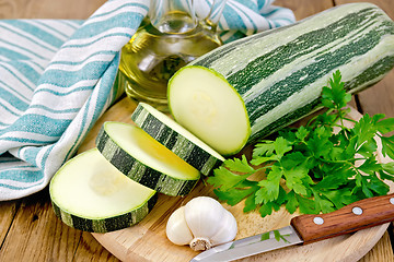 Image showing Zucchini green striped with garlic and oil on board