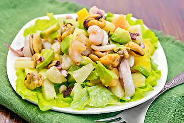 Image showing Salad seafood and fork on dark board