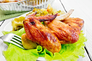 Image showing Chicken wings fried with salad in plate on board