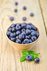 Image showing Blueberries in wooden bowl on board