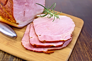 Image showing Ham smoked with rosemary on dark board