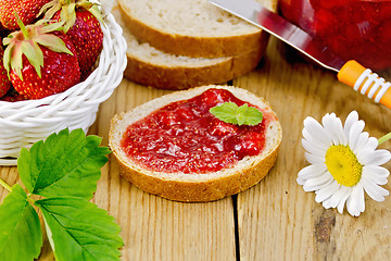 Image showing Bread with strawberry jam and chamomile on board