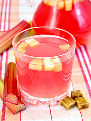 Image showing Compote from rhubarb in glassful and pitcher on linen tablecloth