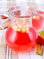 Image showing Compote from rhubarb in jar and glassful on tablecloth