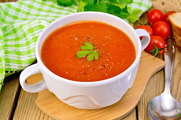Image showing Soup tomato in bowl with spoon on board