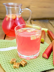 Image showing Compote from rhubarb in glassful and jug with sugar on board