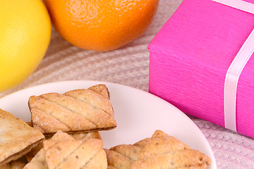 Image showing sweet cake on white plate and fruits and red gift box