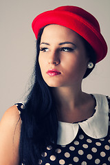 Image showing Young woman with thoughtful look in red hat