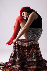 Image showing Young woman in a hat, sitting on a chair