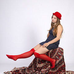 Image showing Young woman in a hat, sitting on a chair