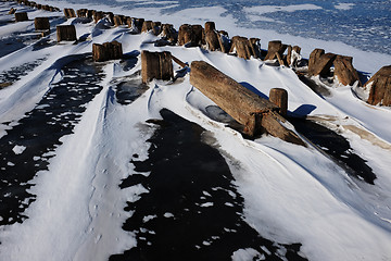 Image showing remains of a wooden pier in the ice on lake