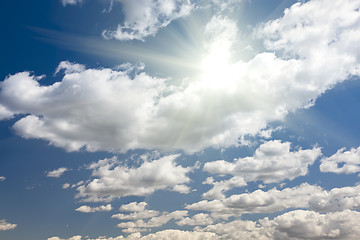 Image showing Deep Blue Sky and Puffy Clouds With Sun Rays