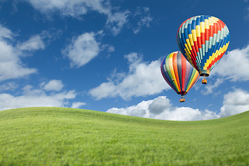 Image showing Hot Air Balloons In Beautiful Blue Sky Above Grass Field 