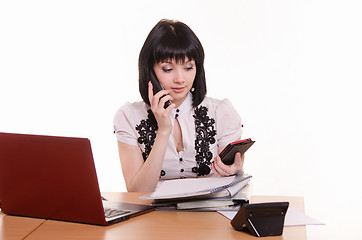 Image showing Call-center worker talking on phone and looking at the other