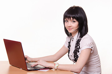 Image showing Call-center employee at a table with laptop