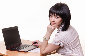 Image showing Call-center worker at a table with laptop