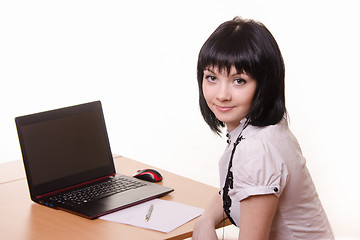 Image showing The girl at the table with a laptop