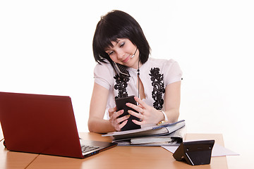 Image showing Call-center worker with phone and a pile of papers