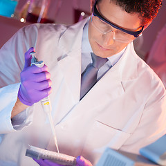 Image showing Researcher pipetting in laboratory.