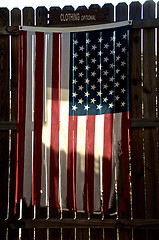 Image showing tattered american flag on fence