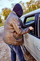 Image showing Hooligan breaking into car