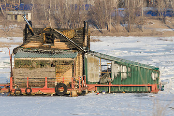 Image showing Burnt wooden structure standing on ice of river