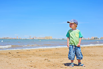 Image showing Small trendy boy standing sandy beach
