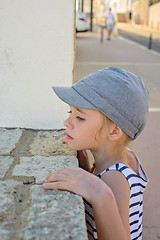 Image showing Little girl looking through a wall