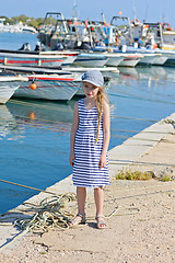 Image showing Little girl in the harbor in striped dress