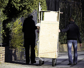 Image showing Men moving things on street