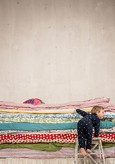 Image showing Child climbs on the bed - Princess and the Pea.