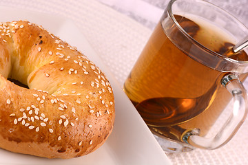 Image showing cup of tea and some cookies on white material background