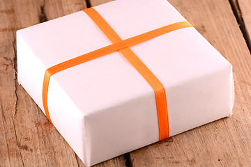 Image showing white gift box on wooden plate