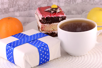 Image showing glass cup of tea, gift box and chocolate cake