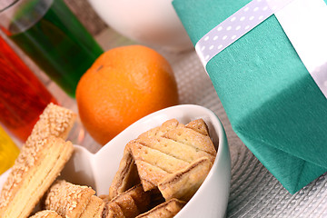 Image showing sweet cake on white plate, gift box, fruits and juice