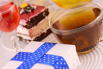 Image showing glass cup of tea, gift box and chocolate cake