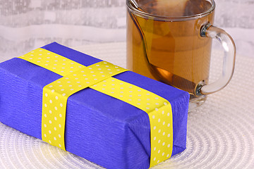 Image showing glass cup of tea and gift box