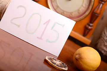 Image showing old lemon and clock on wooden plate