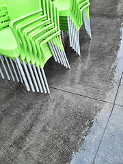 Image showing Stacks of green chairs on a sidewalk