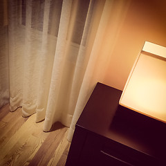 Image showing Cozy lamp in a room with white curtains