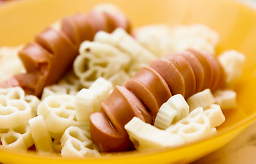 Image showing sausages with curly pasta closeup. macro