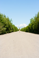 Image showing man with a backpack goes on the sandy road. traveler