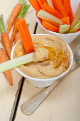 Image showing fresh hummus dip with raw carrot and celery 