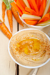 Image showing fresh hummus dip with raw carrot and celery 
