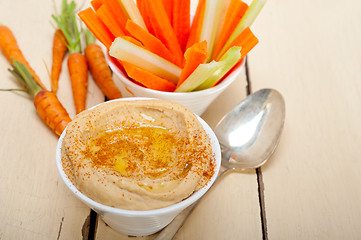 Image showing fresh hummus dip with raw carrot and celery 