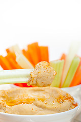 Image showing fresh hummus dip with raw carrot and celery 