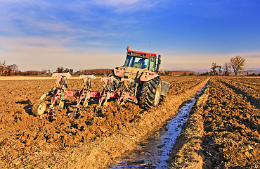 Image showing Tractor plowing field