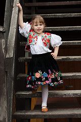 Image showing Little girl in traditional costume on the stairs