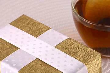 Image showing glass cup of tea and gift box