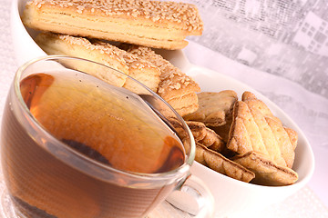 Image showing cup of tea and some cookies on white material background